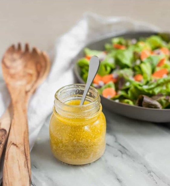 salad dressing in jar next to salad